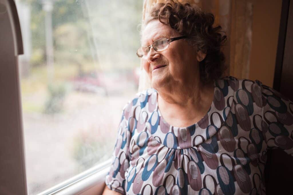 Senior woman looking through the window